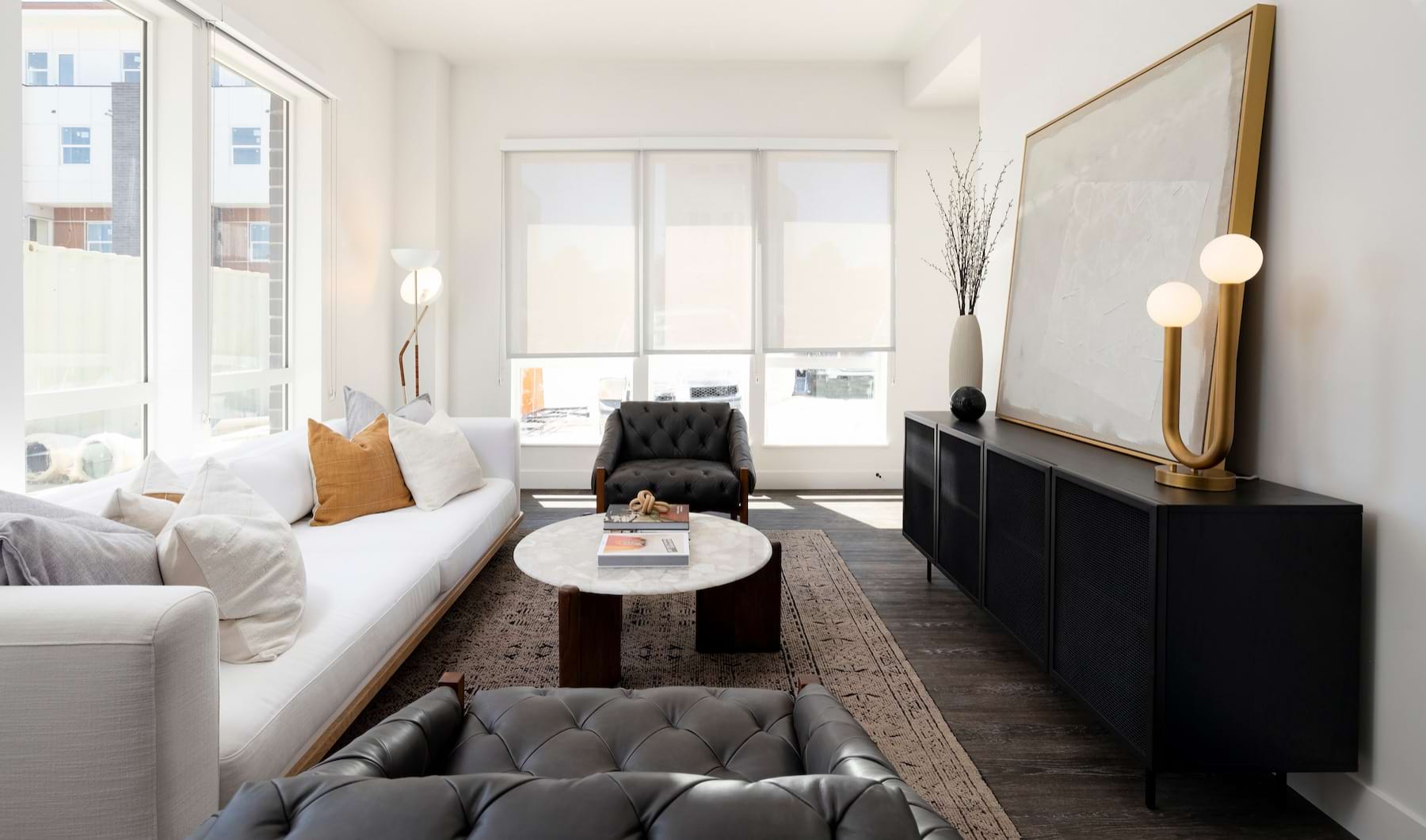 Living Room Spacious and well lit living room with wood flooring, large windows and open access to the kitchen.